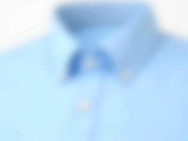 Close-up of a pale blue men's dress shirt neatly tucked